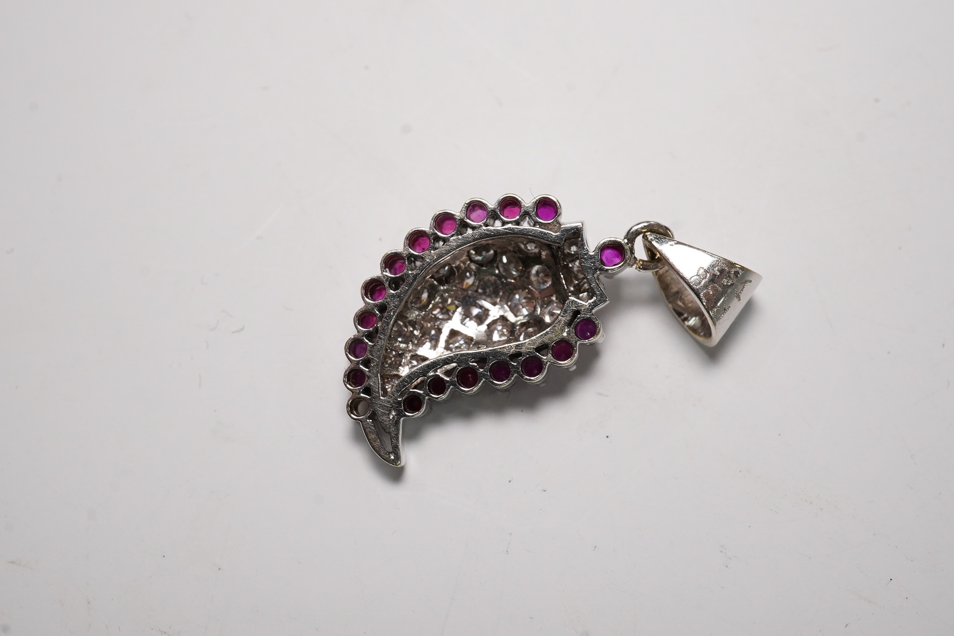 A white metal, diamond and ruby set pendant, 26mm and a pair of 9ct and diamond cluster set ear studs, gross weight 6.1 grams. Condition - fair to good